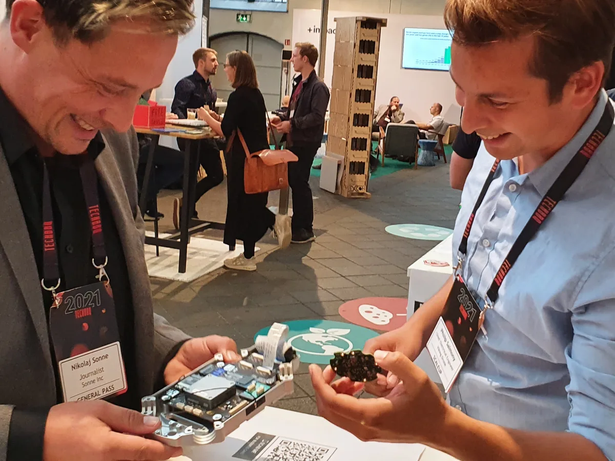 Two engineers examining an opened avionics module together at a technology conference.